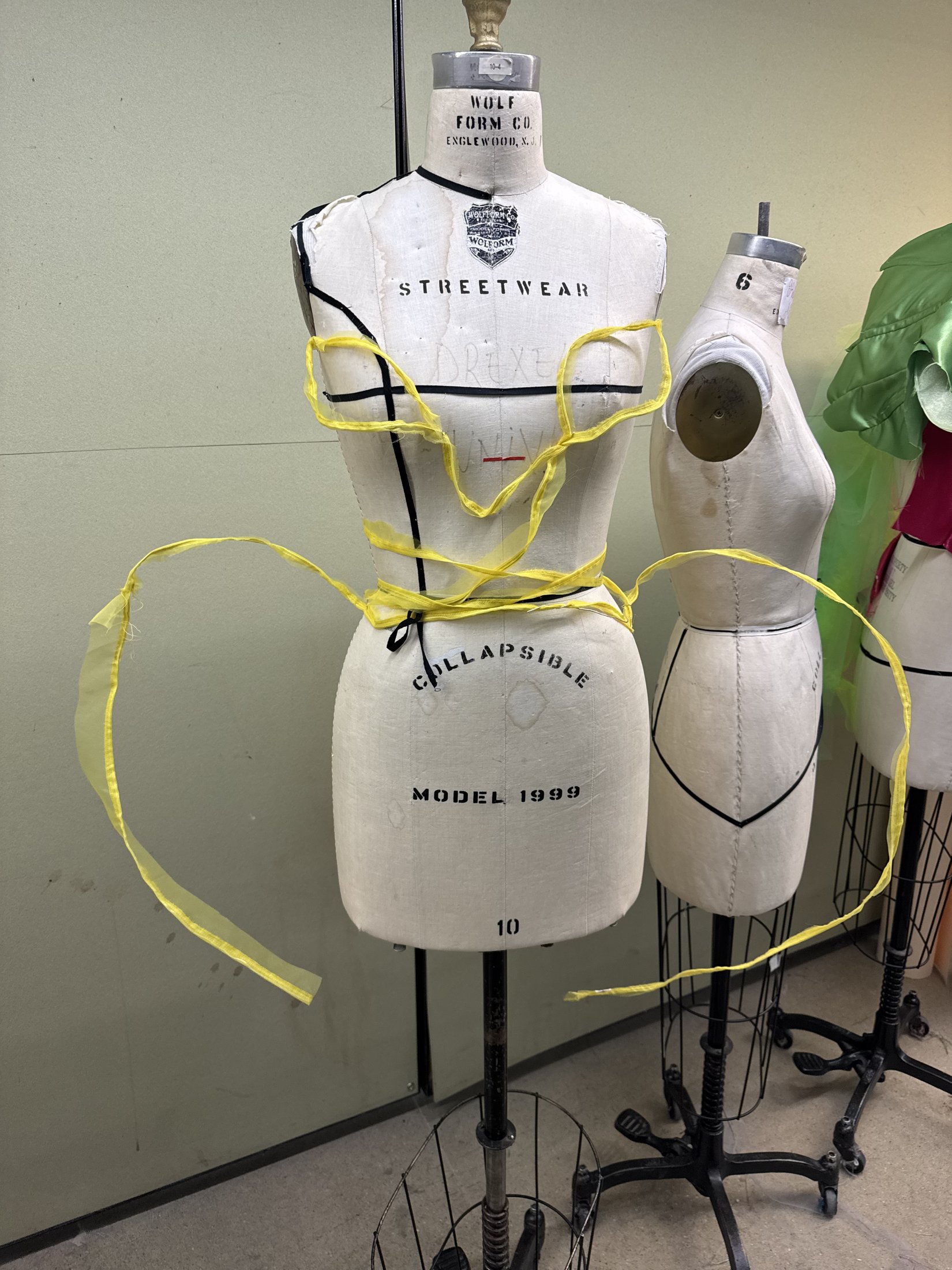 Curved yellow structure on a dress form