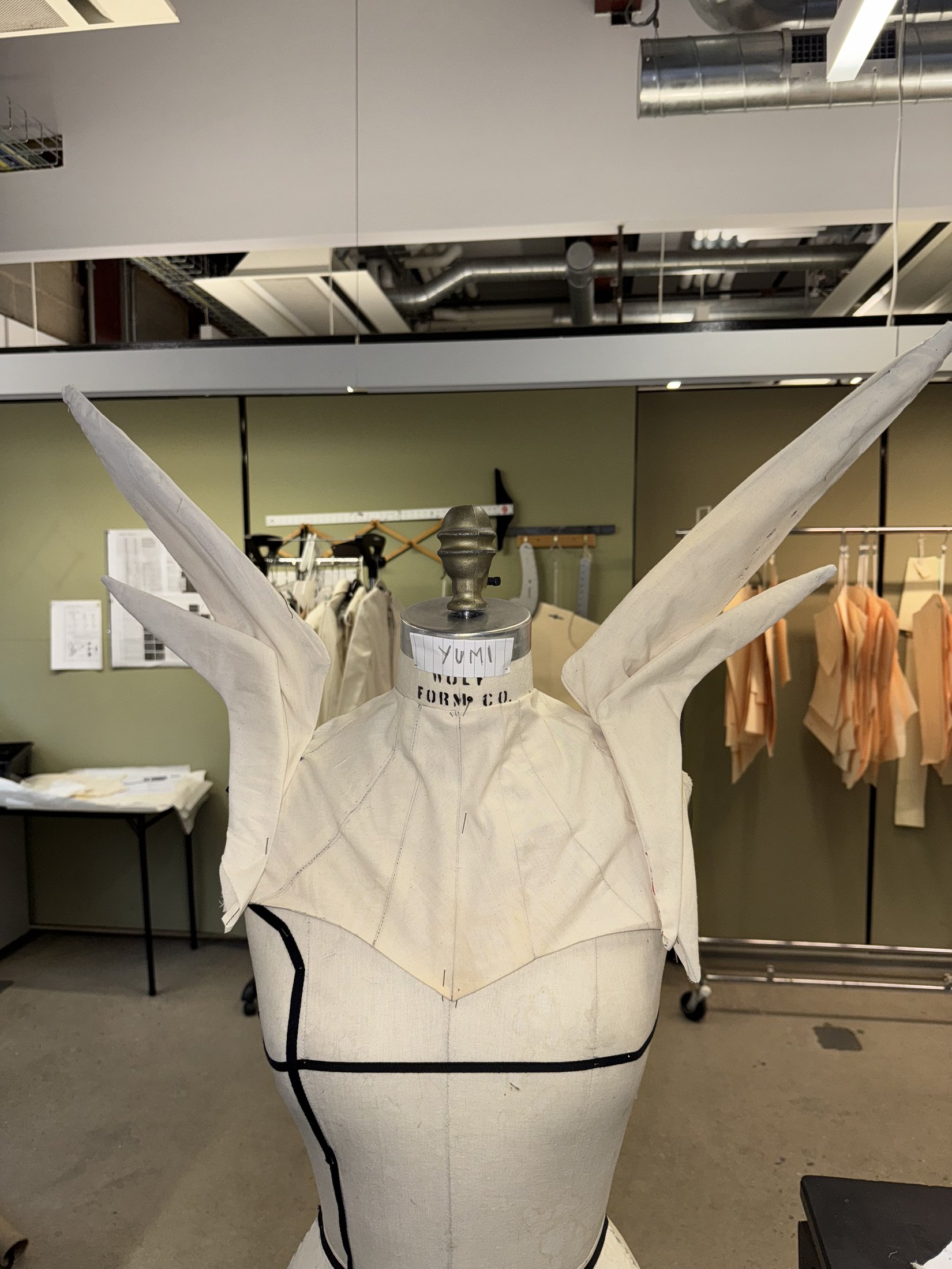 White angular shoulder silhouette on a dress form
